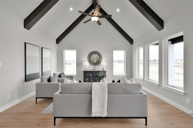 living room with high vaulted ceiling, a ceiling fan, baseboards, light wood-style floors, and beam ceiling