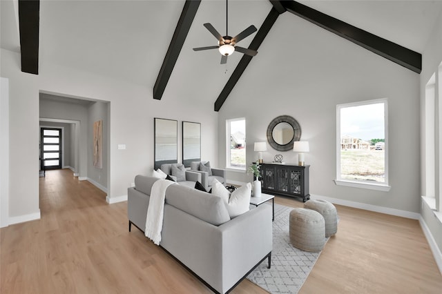 living room with baseboards, light wood-style flooring, high vaulted ceiling, and beamed ceiling