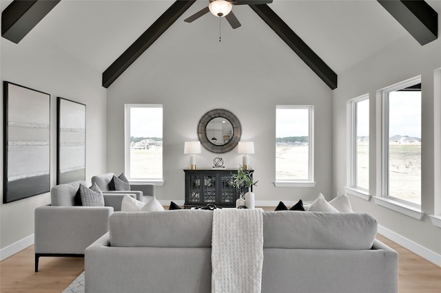 living room featuring high vaulted ceiling, beam ceiling, light wood-style flooring, and baseboards