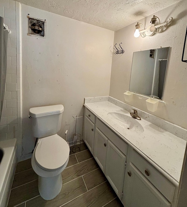 12347 W Village Dr Unit D, Houston, TX 77039 - bathroom featuring toilet, vanity, a textured ceiling, and tub / shower combination