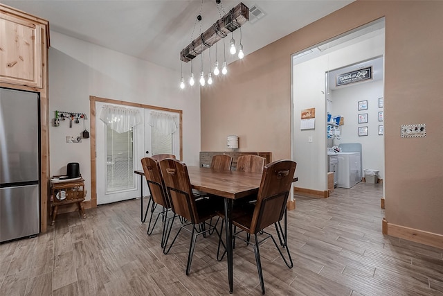 dining space with french doors, light wood finished floors, and baseboards