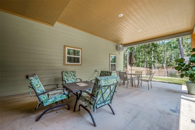 view of patio featuring outdoor dining space and fence