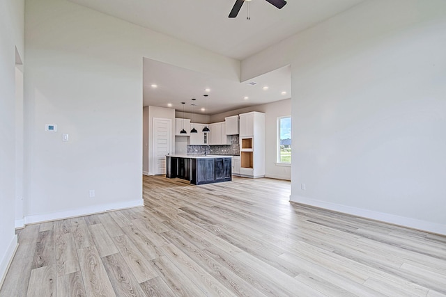 141 Peninsula Point Dr, Montgomery, TX 77356 - unfurnished living room featuring a ceiling fan, light wood-style floors, baseboards, a sink, and recessed lighting