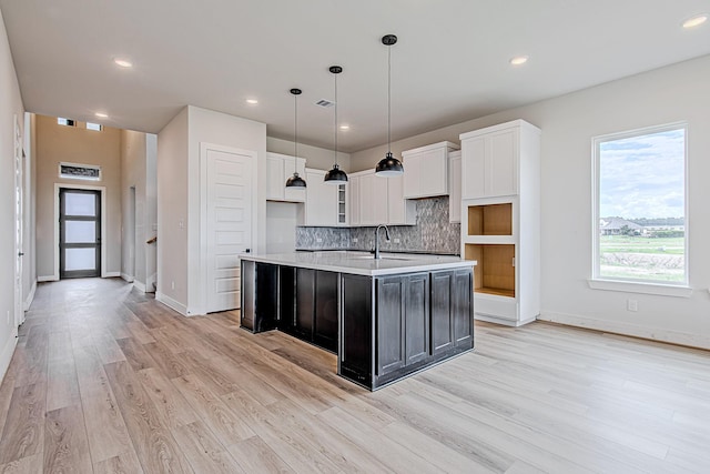 141 Peninsula Point Dr, Montgomery, TX 77356 - kitchen with a sink, light wood-style flooring, white cabinets, a kitchen island with sink, and light countertops