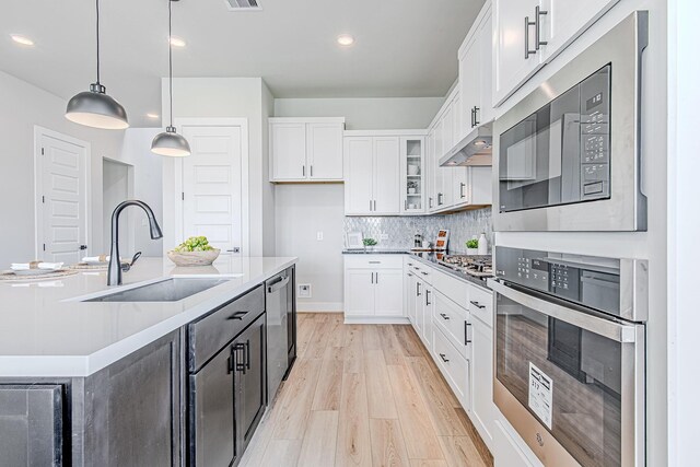 141 Peninsula Point Dr, Montgomery, TX 77356 - kitchen featuring stainless steel appliances, light wood-type flooring, white cabinets, recessed lighting, and backsplash