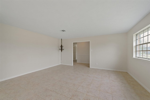 empty room with visible vents, baseboards, and light tile patterned flooring