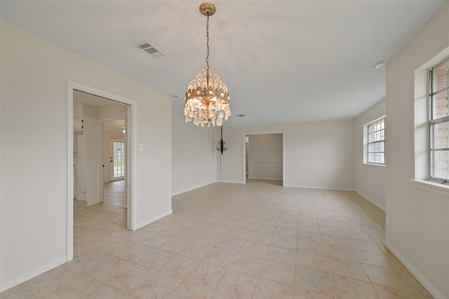 spare room with baseboards, light tile patterned floors, visible vents, and a notable chandelier