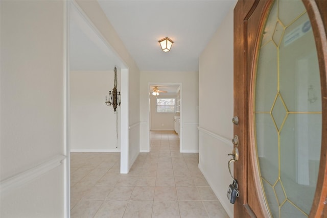 corridor featuring light tile patterned flooring and baseboards