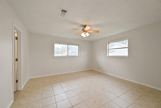 unfurnished room with visible vents, ceiling fan, baseboards, and light tile patterned flooring