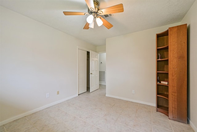 unfurnished bedroom with ceiling fan, a closet, visible vents, and baseboards