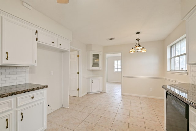 kitchen featuring tasteful backsplash, dark stone countertops, visible vents, and white cabinetry