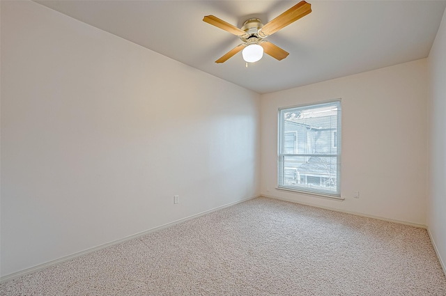 spare room with carpet flooring, ceiling fan, and baseboards