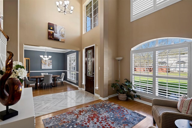foyer featuring a chandelier, a high ceiling, wood finished floors, and baseboards