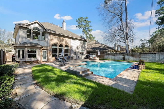 back of house featuring a fenced in pool, a patio area, a fenced backyard, and a chimney