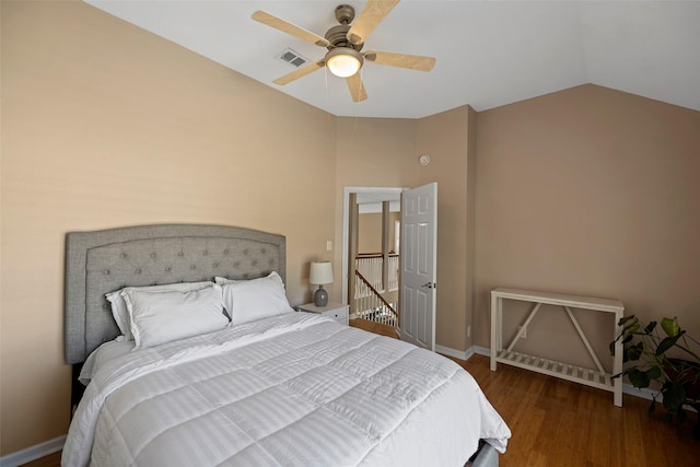 bedroom featuring lofted ceiling, wood finished floors, a ceiling fan, visible vents, and baseboards