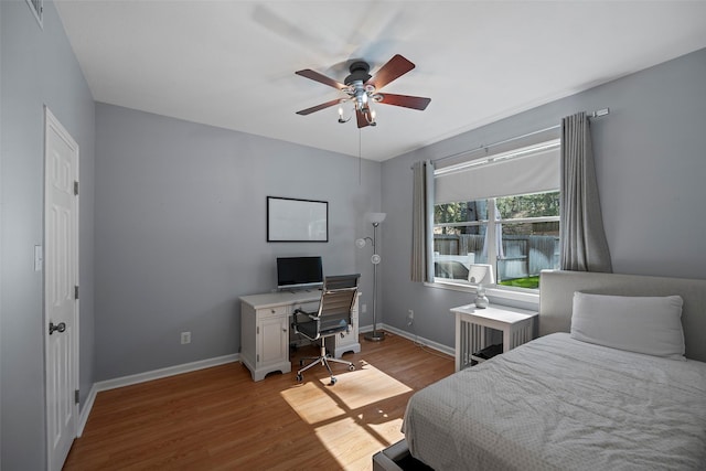 bedroom featuring light wood-type flooring, visible vents, baseboards, and ceiling fan