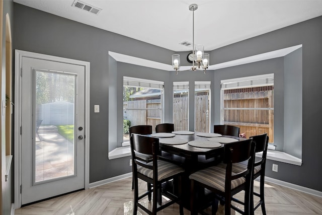 dining space featuring baseboards, visible vents, and a notable chandelier