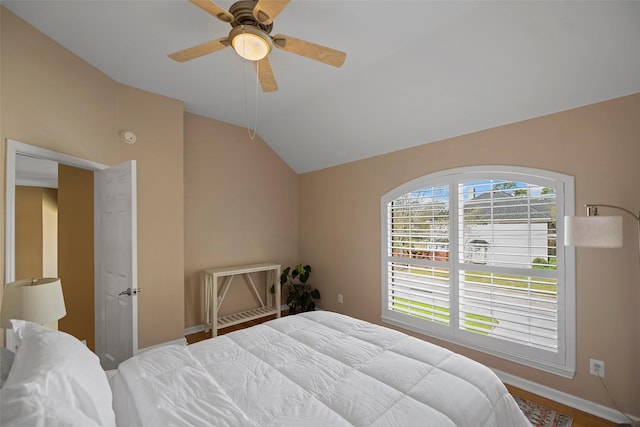 bedroom with vaulted ceiling, ceiling fan, and baseboards