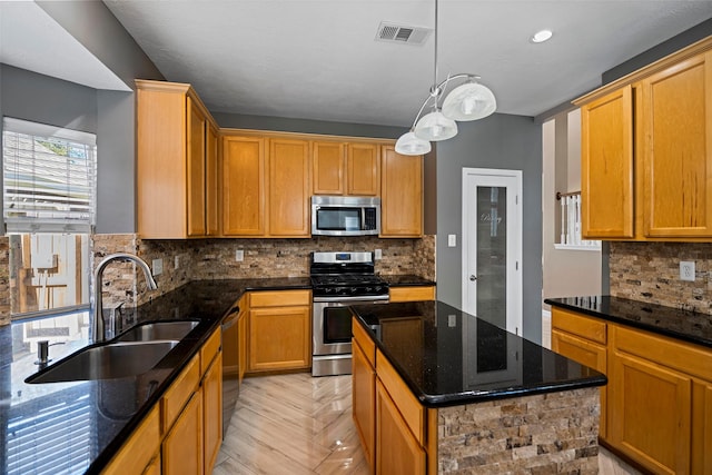 kitchen with tasteful backsplash, visible vents, appliances with stainless steel finishes, a sink, and dark stone counters