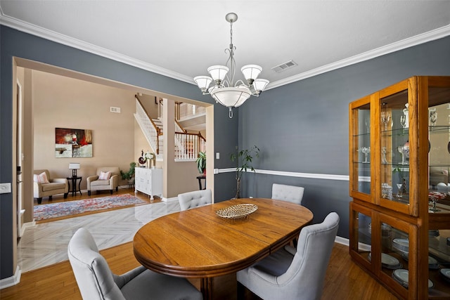 dining space featuring ornamental molding, visible vents, stairs, and an inviting chandelier