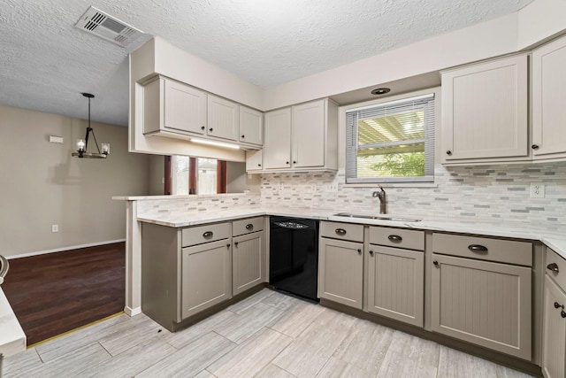 kitchen featuring gray cabinetry, a peninsula, a sink, visible vents, and dishwasher