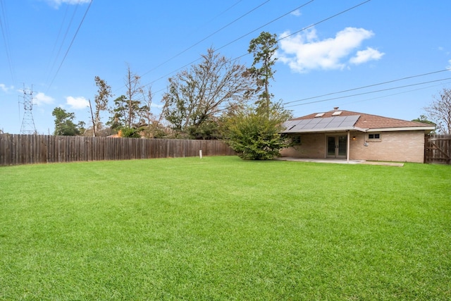 view of yard featuring a patio area, a fenced backyard, and french doors