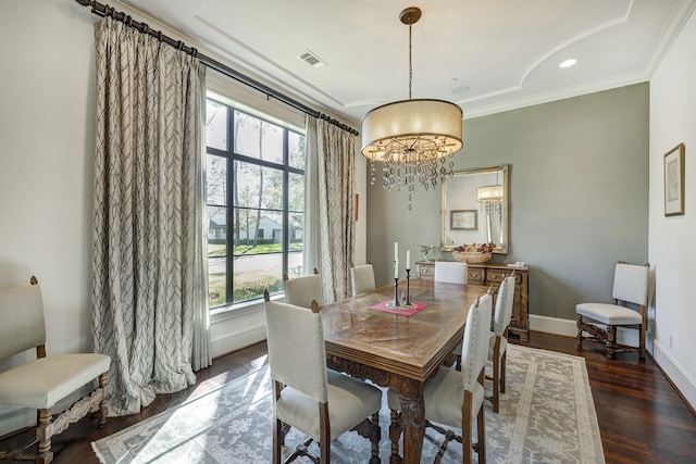 dining room with visible vents, baseboards, ornamental molding, an inviting chandelier, and wood finished floors