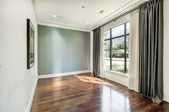 empty room featuring visible vents, ornamental molding, hardwood / wood-style flooring, recessed lighting, and baseboards