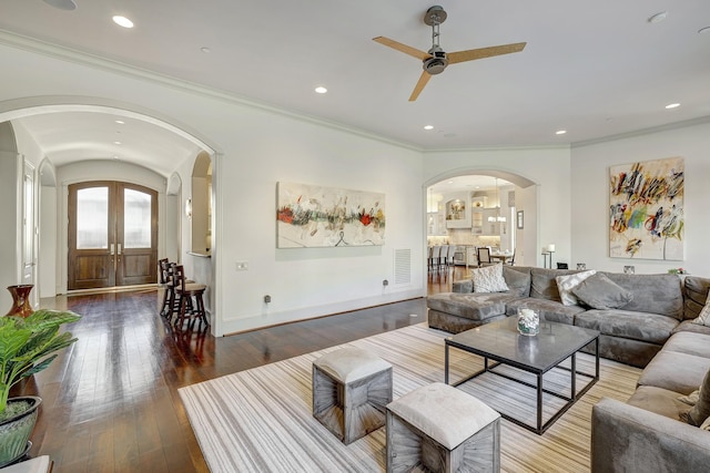 living area featuring visible vents, french doors, arched walkways, and wood-type flooring