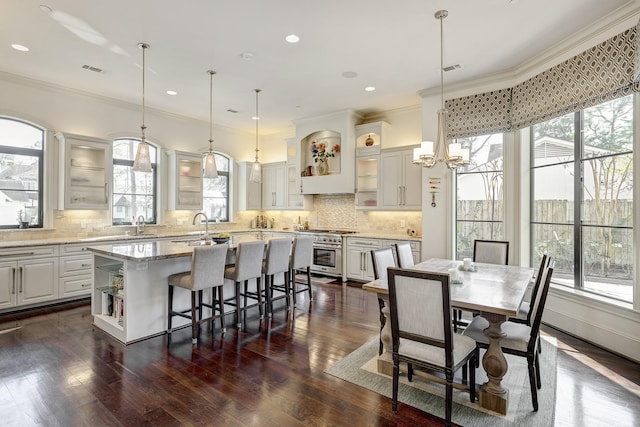 dining space with visible vents, crown molding, an inviting chandelier, and dark wood-style flooring