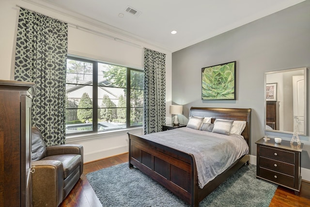 bedroom with dark wood finished floors, visible vents, multiple windows, and baseboards