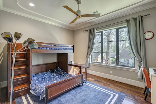 bedroom with visible vents, a ceiling fan, wood finished floors, crown molding, and baseboards