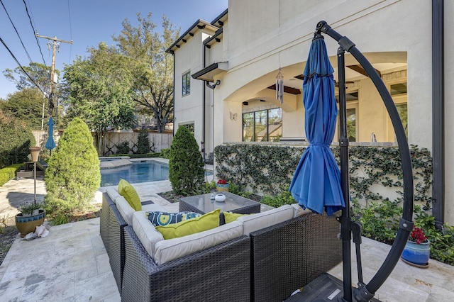 view of patio with an outdoor living space, a fenced in pool, an in ground hot tub, and fence