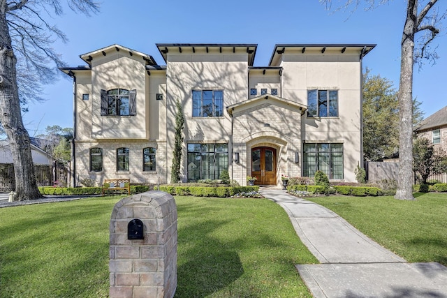 view of front of house featuring french doors, fence, a front lawn, and stucco siding