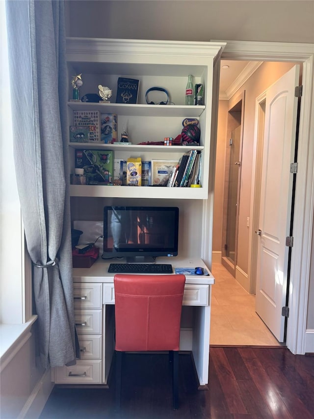 office area featuring crown molding, wood finished floors, and built in study area