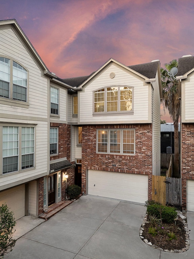 view of front of house featuring a garage, brick siding, and concrete driveway