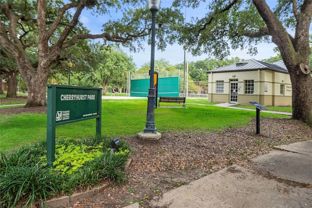 view of property's community featuring a yard and fence