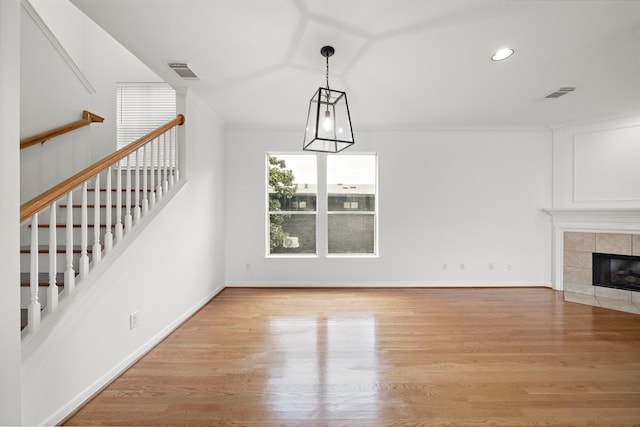 unfurnished living room with visible vents, a fireplace, baseboards, and wood finished floors