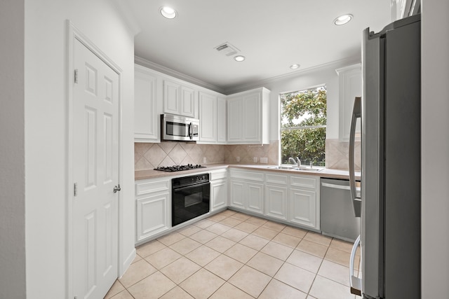 kitchen with visible vents, a sink, white cabinetry, stainless steel appliances, and light countertops