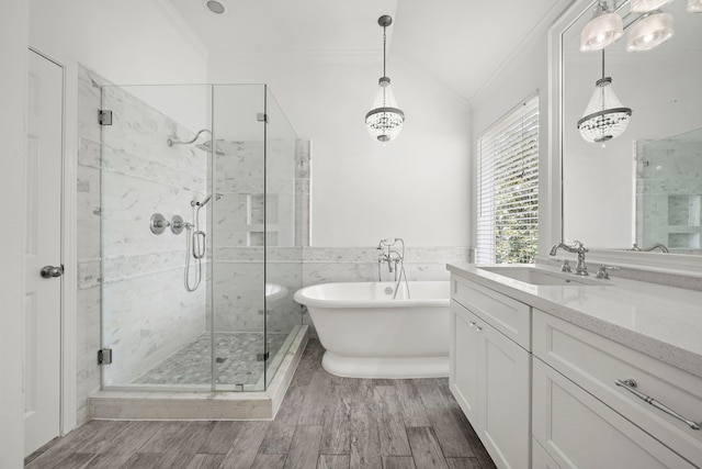 full bath with a soaking tub, a shower stall, wood finished floors, and ornamental molding