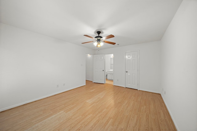 unfurnished bedroom with connected bathroom, baseboards, light wood-style floors, and ceiling fan