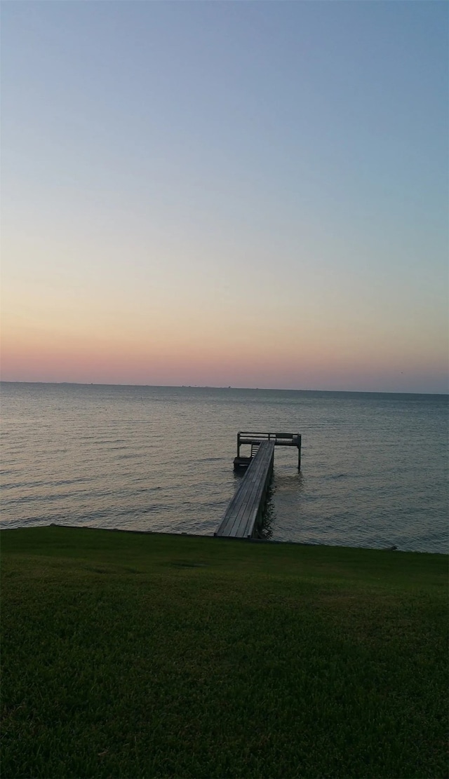 dock area with a water view and a yard