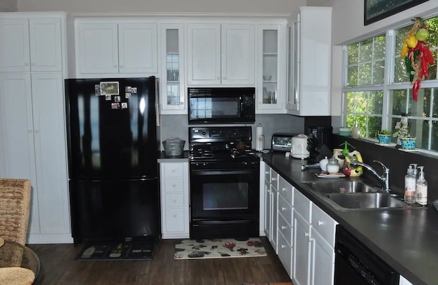 kitchen featuring black appliances, a sink, dark wood finished floors, and white cabinets