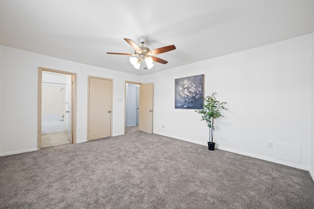 unfurnished bedroom with ensuite bath, carpet flooring, a ceiling fan, and baseboards