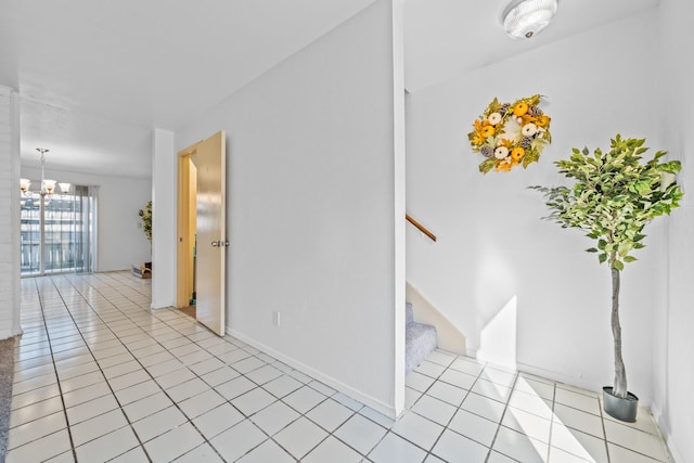 empty room with light tile patterned floors, stairway, and a chandelier