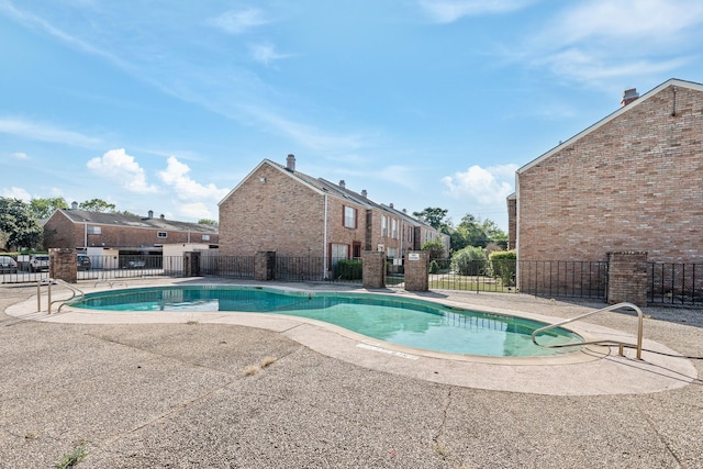 community pool featuring a patio area and fence