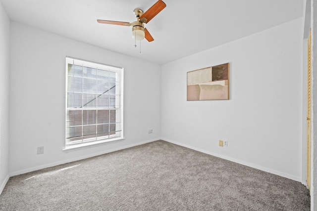 spare room with ceiling fan, carpet flooring, and baseboards