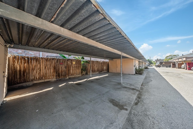 covered parking lot featuring fence