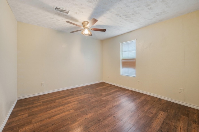 empty room with visible vents, ceiling fan, a textured ceiling, wood finished floors, and baseboards