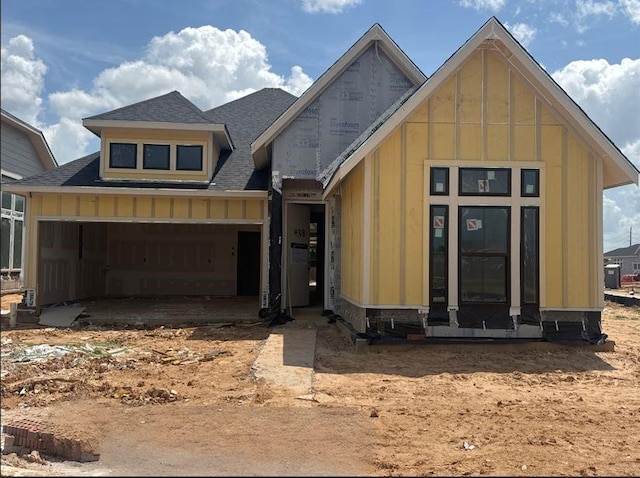unfinished property featuring board and batten siding and a shingled roof